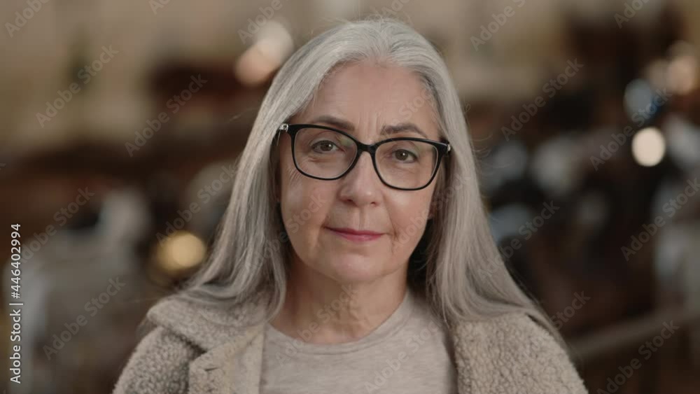 Portrait ofaged woman in eyeglasses posing at goat farm Portrait ofaged woman in eyeglasses posing at goat farm