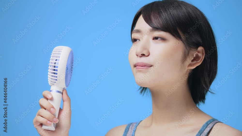 ハンディファンを使う女性 ポータブル扇風機 ハンディファンを使う女性 ポータブル扇風機