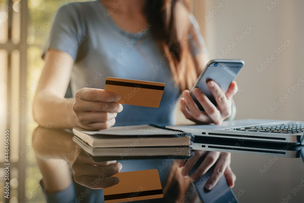 Hands holding credit card and using laptop in office home. Online shopping. Hands holding credit card and using laptop in office home. Online shopping.