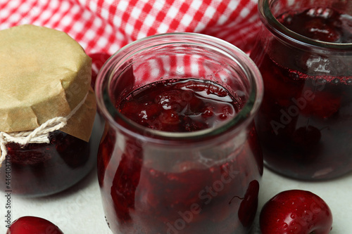 Glass jar with cherry jam, close up
