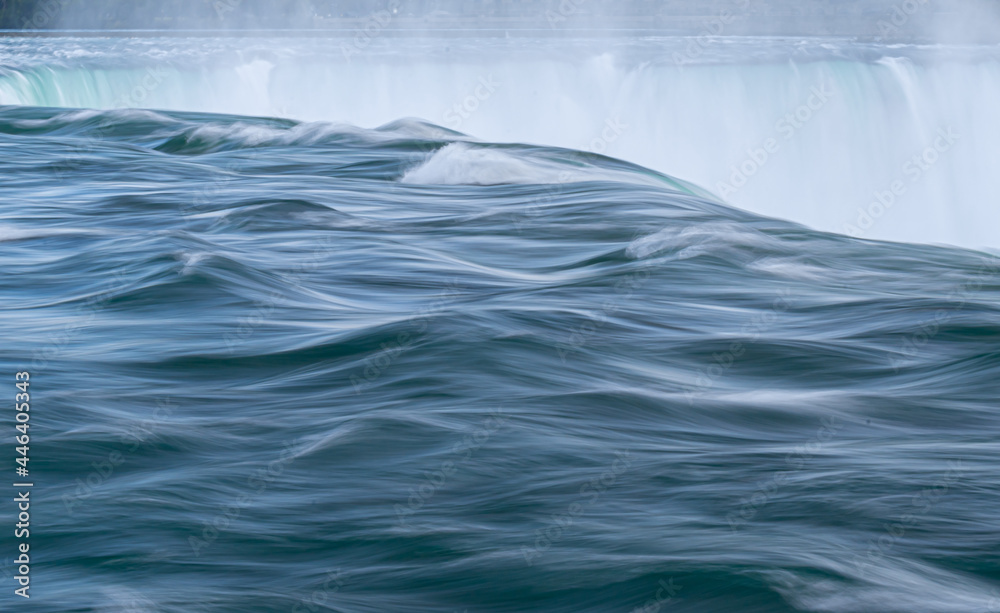 Water flowing in the river with ripples before falling in a waterfall in Niagara Falls Water flowing in the river with ripples before falling in a waterfall in Niagara Falls