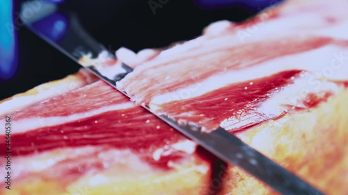 Ham plate. Appetizing traditional Spanish delicious slice Iberian jamón or cured ham leg. Person holding tweezers. Spanish gourmet food. Typical Spanish or Catalan food. Iberian pork. 4k video. photo