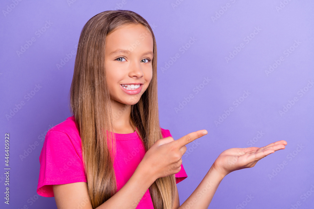 Photo of young happy cheerful positive girl point finger hold hand empty space isolated on purple color background