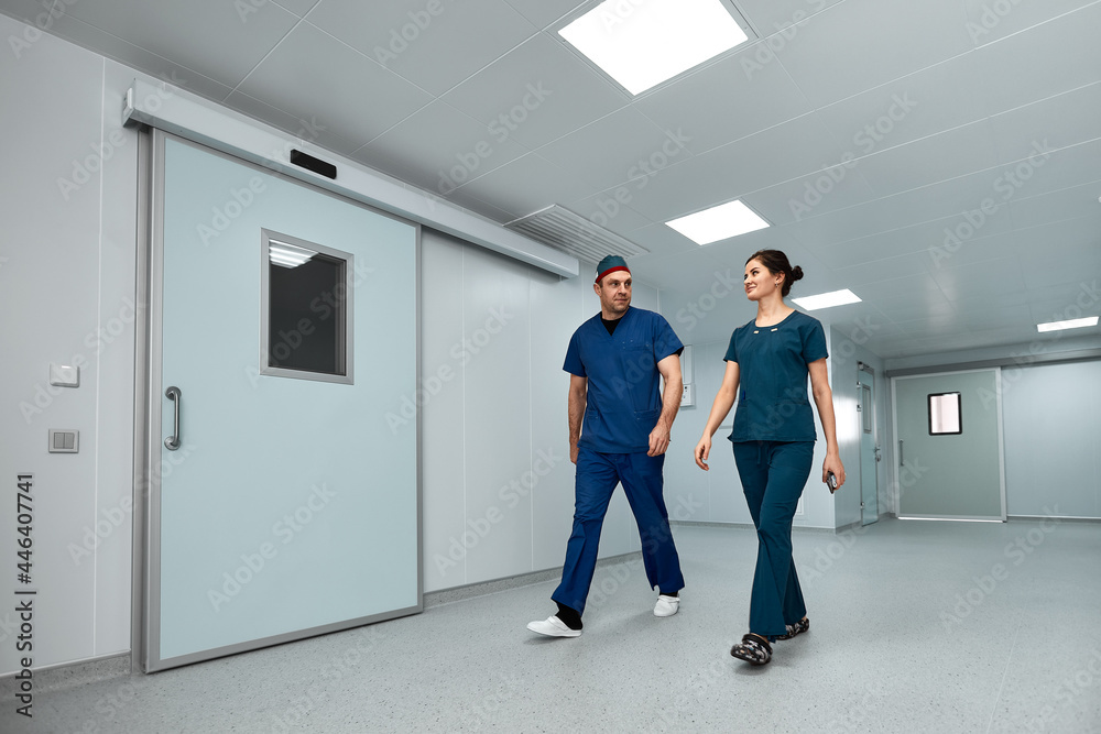 Doctors surgeons walk along the corridor of the clinic in suspense, preparing for a complex operation. Doctors surgeons walk along the corridor of the clinic in suspense, preparing for a complex operation.