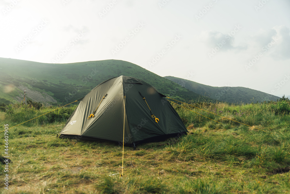 Camping tent in campground at national park. Tourists camped on the carpathian mountains. View of tent on meadow in forest.
