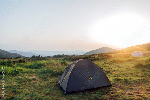 Tourist tent in the mountains view and sunrise. Domestic tourism  active summer trip. Ecotourism  camping  sports mountain hiking.