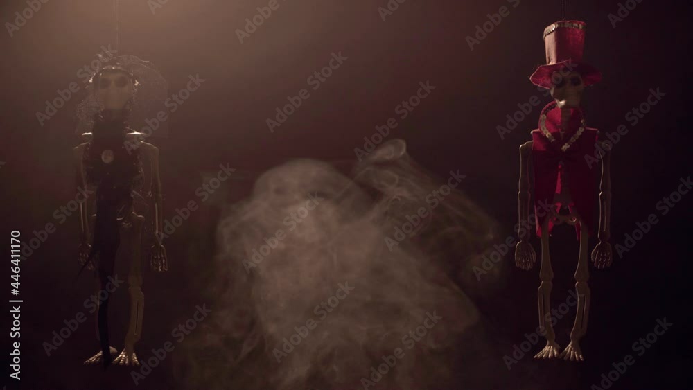 Two skeleton, decoration for Day of The Dead swing in smoke. Video 4k.