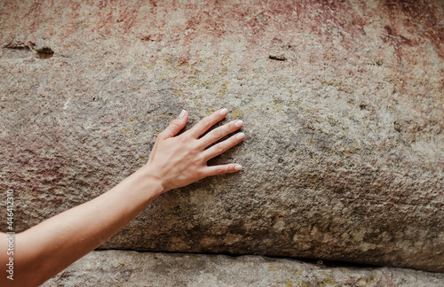Woman hand touching the rock surface