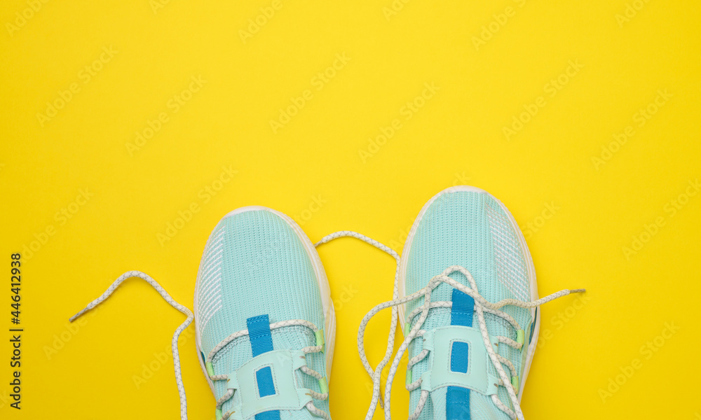 Fototapeta para niebieskich tekstylnych tenisówek na żółtym tle
