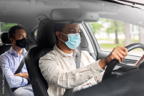 transportation, health and people concept - indian male taxi driver driving car with passenger wearing face protective medical mask for protection from virus disease © Syda Productions