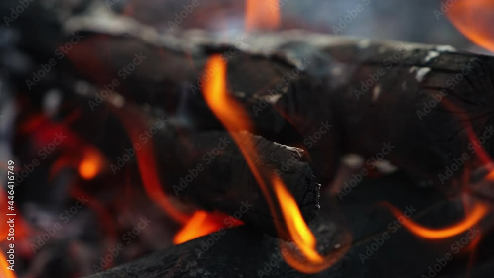 Burning bonfire with logs of wood. Burning hot firewoods fire sparks on dark background Burning bonfire with logs of wood. Burning hot firewoods fire sparks on dark background