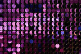 shiny texture of the background, a set of round purple sequins sewn on the fabric like fish scales