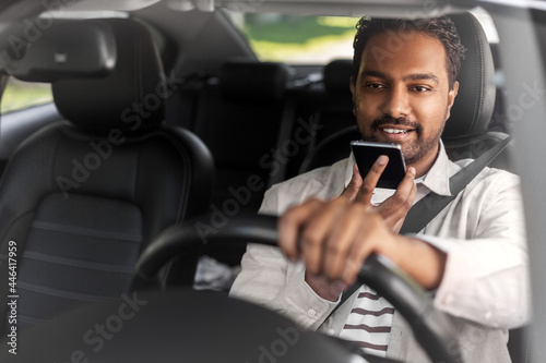 transport, people and technology concept - smiling indian man or driver driving car and recording message using voice command recorder on smartphone © Syda Productions