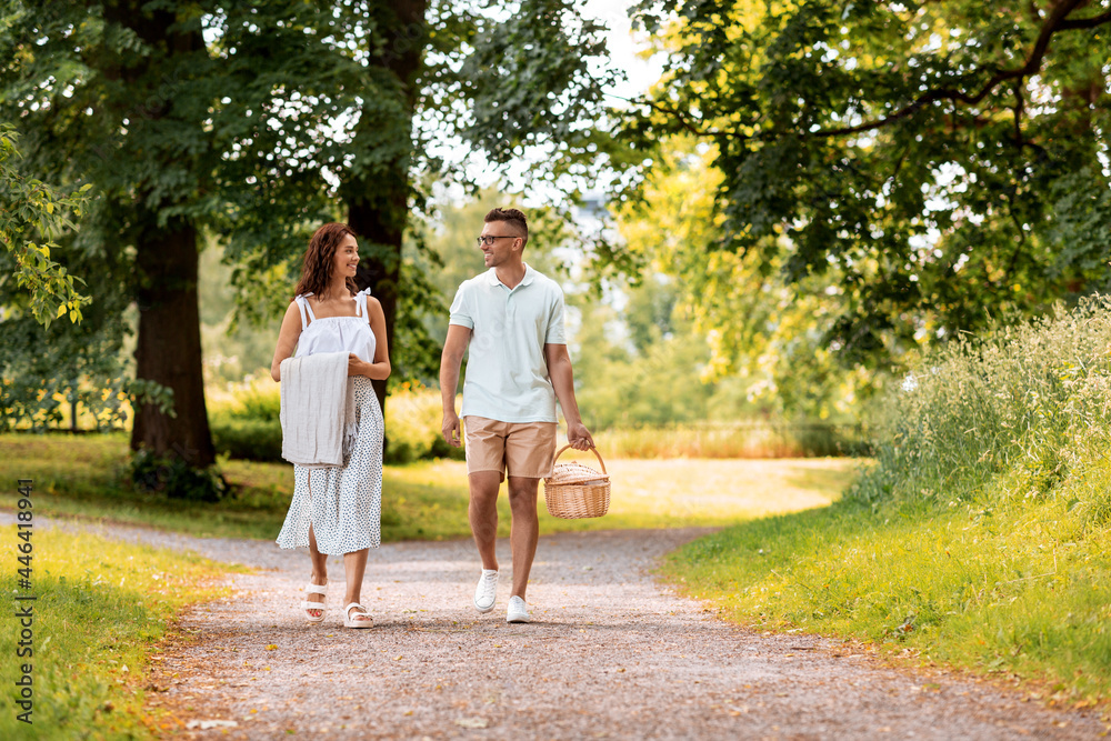 leisure, vacation and people concept - happy couple with picnic basket and blanket walking at summer park leisure, vacation and people concept - happy couple with picnic basket and blanket walking at summer park
