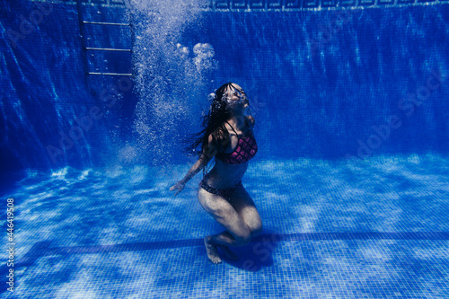 happy caucasian woman diving in swimming pool. underwater view. Summer time and vacation concept