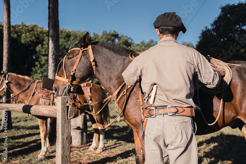 Argentine gaucho with horses wearing work clothes, with gaucho panties and beret, traditional Argentine scene.