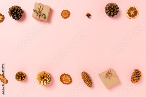 Minimal creative flat lay of christmas traditional composition and new year holiday season. Top view winter christmas decorations on pink background with blank space for text. Copy space photography.