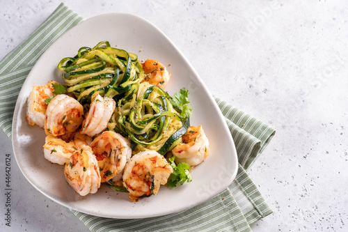 zucchini pasta with shrimps on white plate