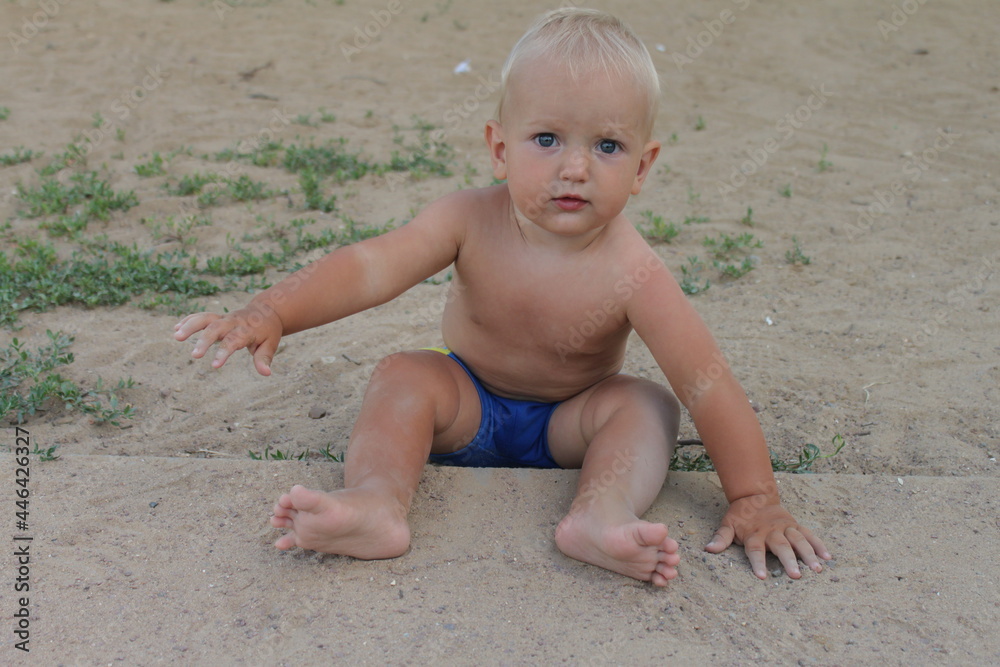 child toddler boy playing on the beach in sand in summer child toddler boy playing on the beach in sand in summer