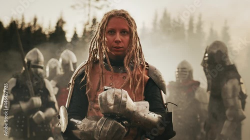 Epic Battlefield: Portrait of Powerful Female Leader Warrior Holding Sword, Ready for Battle. Woman Knight General in Dark Age Medieval War against Invasion. Dramatic, Cinematic, Historic Reenactment photo