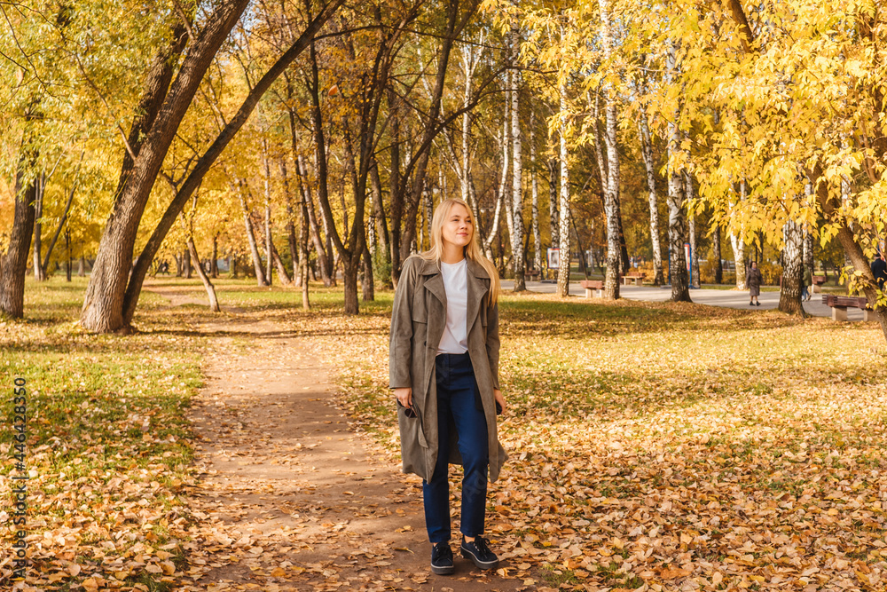 Obraz premium Woman in coat walking in autumn park.