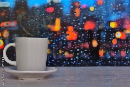Steaming coffee cup on a rainy day window background with copy space for text