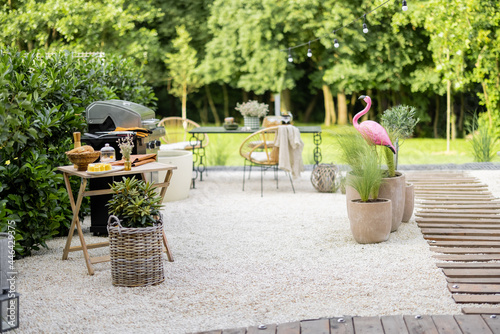 фотографія Beautiful backyard in natural boho style with garden furniture, greens and pink