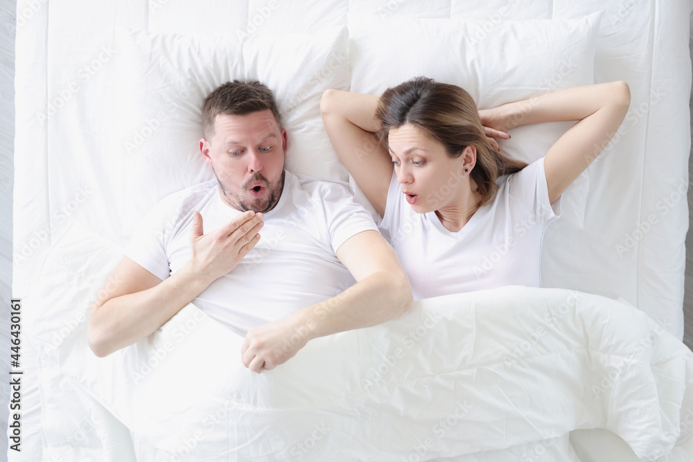 Astonished man and woman look under covers Astonished man and woman look under covers