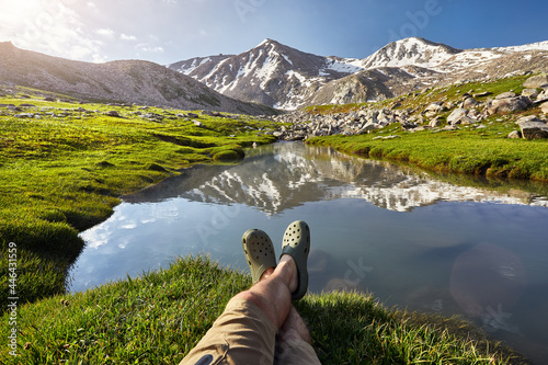 Hiker man rest at mountain lake photo