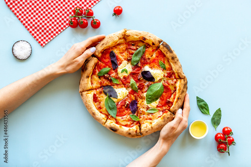 Female hands with italian pizza margherita, top view