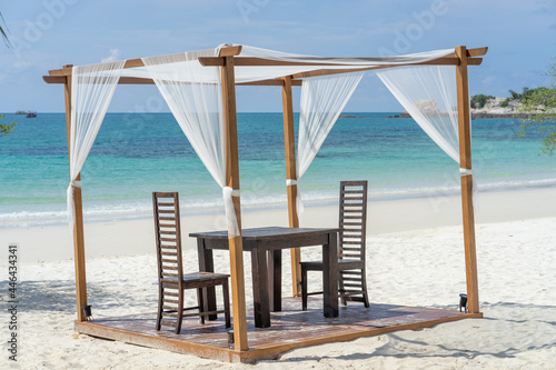 Beach tent setup on clear white sand table and chairs