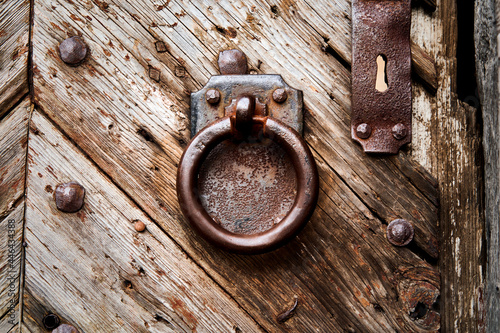 Obraz na plátně Heavy rusty iron door knocker, ring in front of rectangular iron plate on weathe