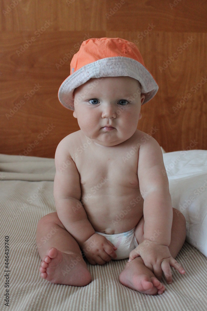 portrait of a cute lovely child boy sitting smiling in an orange hat portrait of a cute lovely child boy sitting smiling in an orange hat