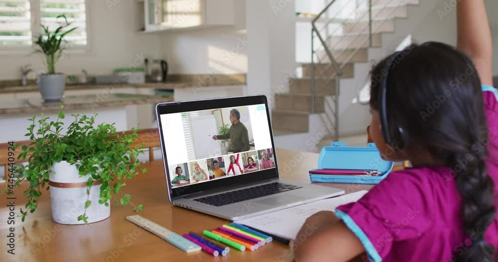 Schoolgirl using laptop for online lesson at home, with diverse teacher and class on screen Schoolgirl using laptop for online lesson at home, with diverse teacher and class on screen