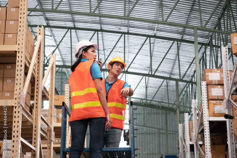 Warehouse worker discuss about stock in the automotive part warehouse.