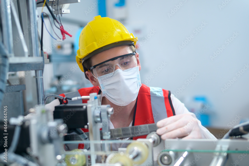 Quality control (QC) engineer monitoring and checking machine system in manufacturing factory Quality control (QC) engineer monitoring and checking machine system in manufacturing factory