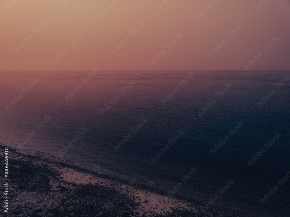 Sunrise seascape over the foggy Atlantic Ocean. Beach landscape over Falmouth Height on Cape Cod. Soft pastel image in pink and dark blue colors. Sunrise seascape over the foggy Atlantic Ocean. Beach landscape over Falmouth Height on Cape Cod. Soft pastel image in pink and dark blue colors.