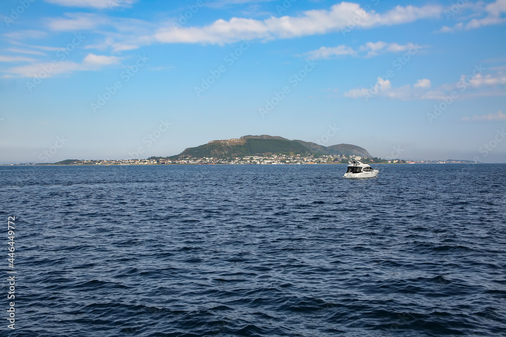 View of the beautiful landscape of the archipelago, islands and fjords from the port of Alesund, Norway. Small boat sailing to the island. View of the beautiful landscape of the archipelago, islands and fjords from the port of Alesund, Norway. Small boat sailing to the island.