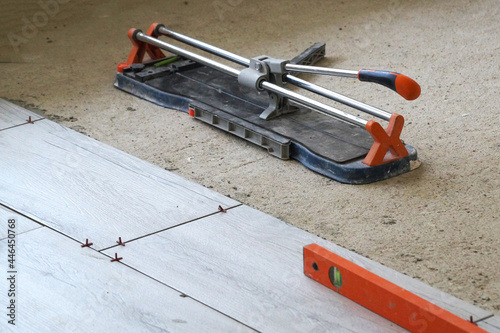 Wallpaper Mural measuring level and manual tile cutter on porcelain stoneware floor Torontodigital.ca