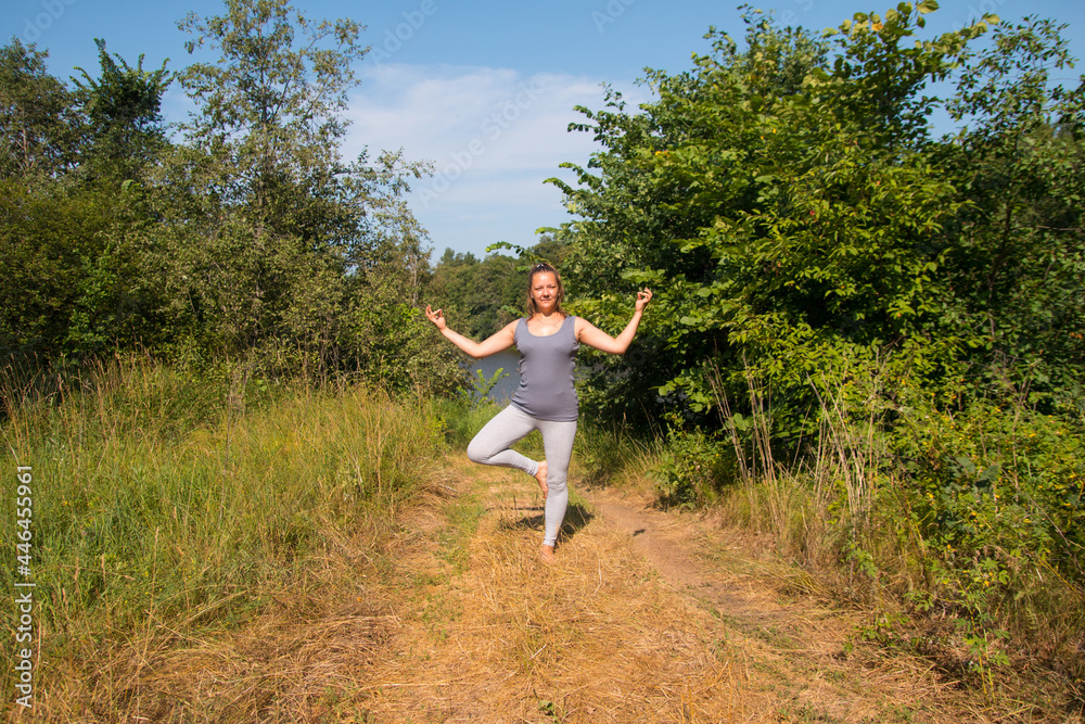 A woman does gymnastics in nature. Yoga meditation