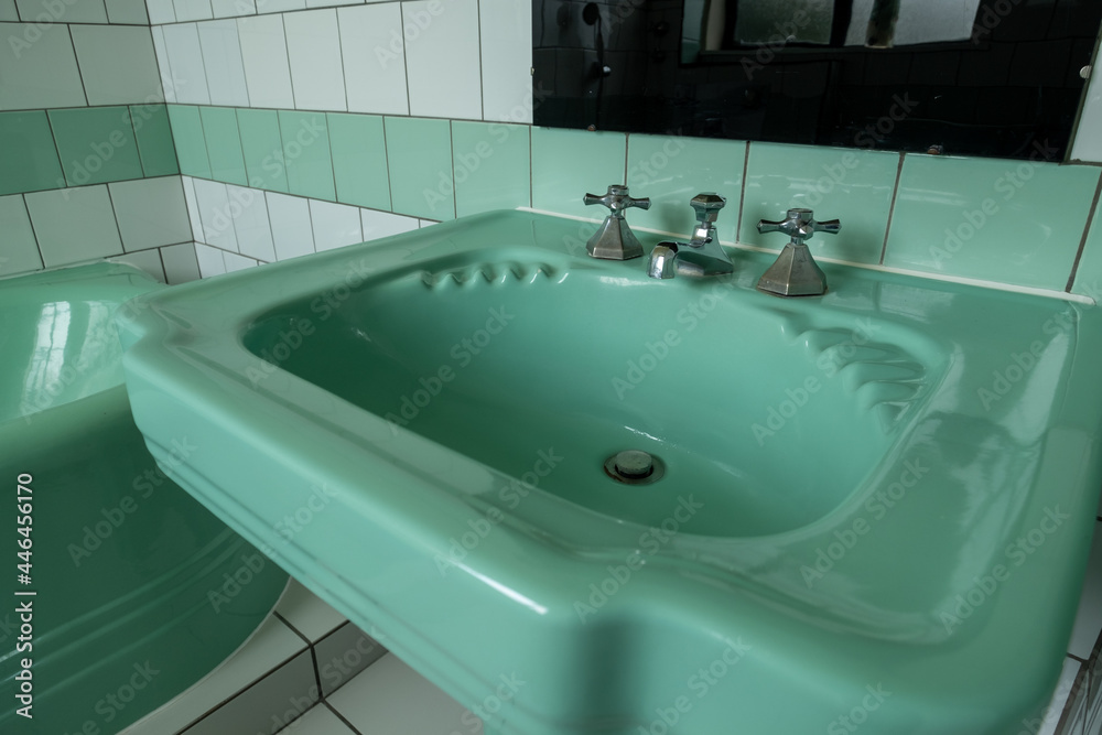Fototapeta premium Close up of original green vintage retro 1930s deco wash basin and stainless steel taps.