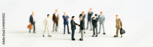 Fototapeta Naklejka Na Ścianę i Meble -  Miniature businessman shake hand partner client customers on stage with success dealing business using as contract commitment agreement investment and partnership business development cover page ads