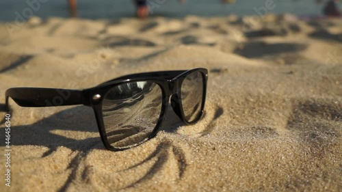 Mirror sunglasses on the sand beach with reflection