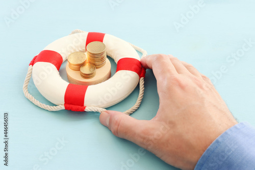 Concept image of lifebuoy and stack of coins. idea and metaphor of financial support in times of crisis photo