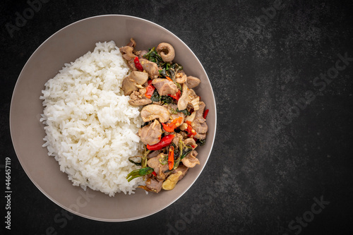 Khao Pad Ka Prao Kruang Nai Gai, Thai food, streamed rice with basil stir fried chicken offal, variety meats, pluck or organ meats on dark tone background with copy space for text, top view