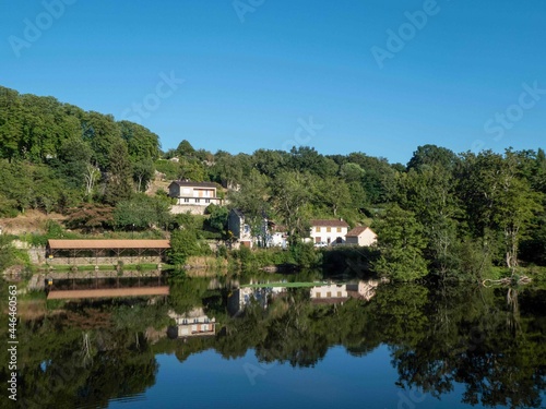 French houses and old communal wash house reflecting in the River Vienne in L Isle Jordain France