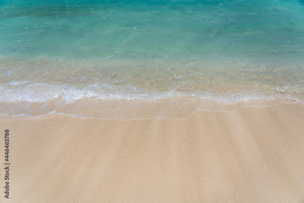 Turquoise waves washing up on a white sand beach