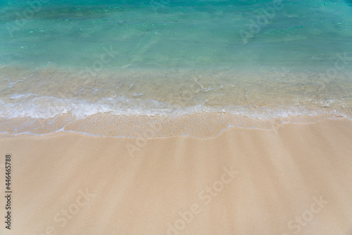 Turquoise waves washing up on a white sand beach