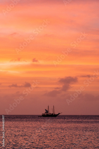 A boat silhouette against a Caribbean sunset