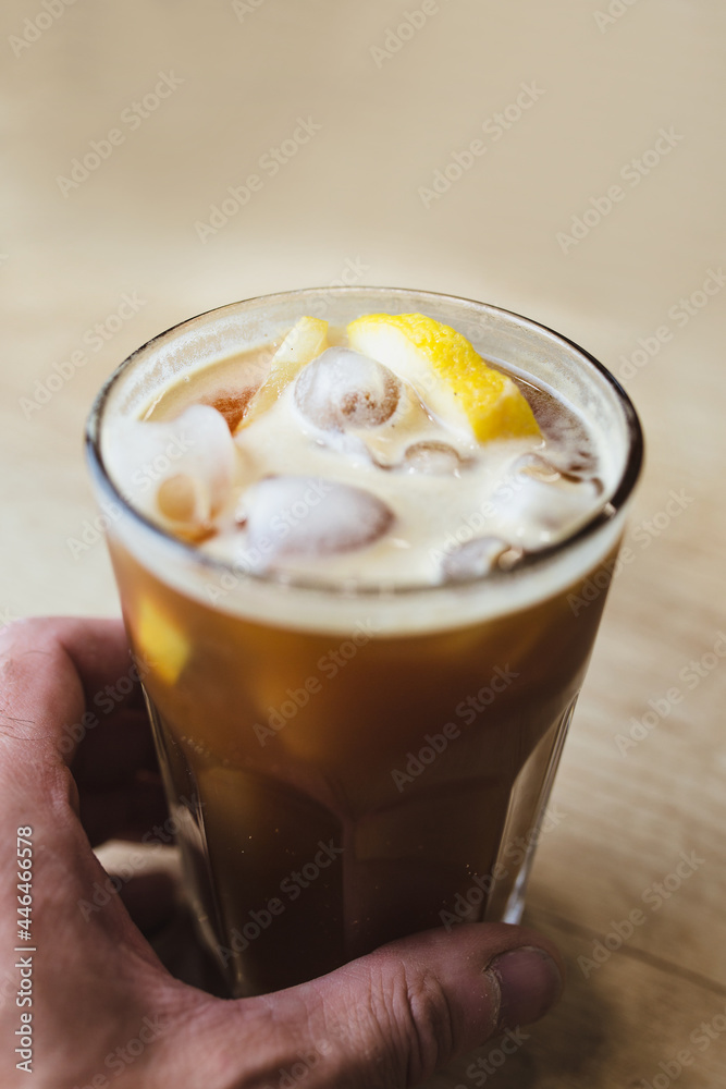 Appetizing cool refreshing drink with ice and lemon in a glass - ice coffee